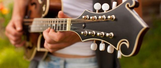 Kvinne spiller gitar. Realiser drømmeprojektene med forbrukslån.