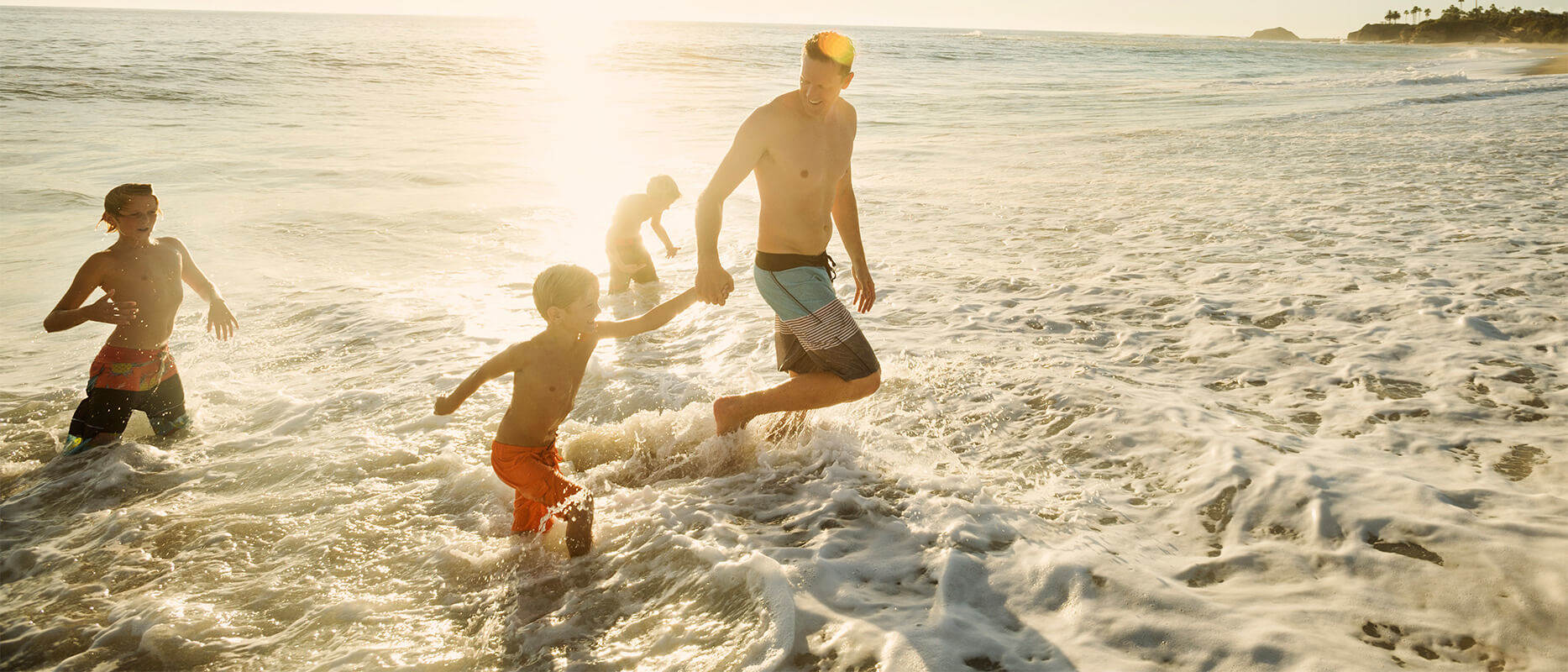 Familie på stranden. Få rabatt på din reise med re:member reward.